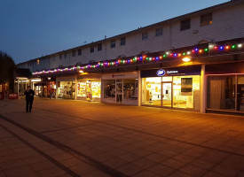 An image showing a row of shops with newly fitted lights along them.